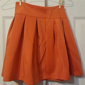 Orange pleated mini-skirt